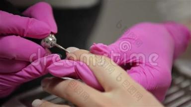 美容师在美容沙龙里为一个美容师磨指甲吧。 手指指甲处理、研磨和抛光